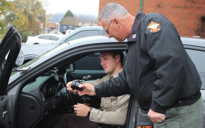 Megan Broome/The Clayton Tribune. Corporal Clinton Scott, left, and Captain Sam Jones install an in-car radar unit in a patrol vehicle at the Rabun County Sheriff’s Office.