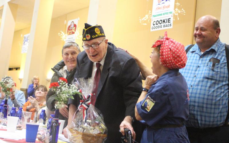 Megan Broome/The Clayton Tribune. Thomas Slowen, left, Carol Cain, dressed as Rosie the Riveter, and Anthony Worley congratulate Korean War Army Veteran Lloyd Hunter, as he is honored at the Veterans Appreciation Dinner held at the Rabun County Civic Center Nov. 11, 2021. Hunter is 93 years old and has owned Hunter Funeral Home since 1969. He is part of American Legion Post 220. He also worked in the Coroner’s Office for 52 years.