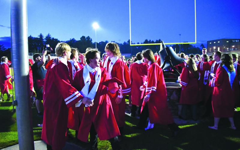 Enoch Autry/The Clayton Tribune. RCHS graduates celebrate after ringing the bell.