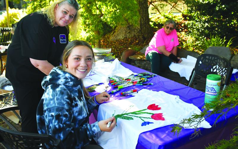 Megan Broome/The Clayton Tribune. Ashley Slappey, Sherry, and Calista design T-shirts to bring awareness to October as “Domestic Violence Awareness Month” during the Hope Walk event in downtown Clayton Oct. 5.