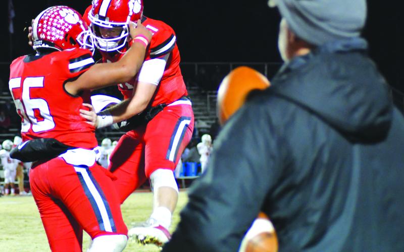 Enoch Autry/The Clayton Tribune. Rabun County senior quarterback Keegan Stover leaps up in congratulations with defensive lineman Cesar Cruz (66) after the Wildcats make a fourth-down stop by recovering a fumble against Social Circle on Nov. 18 at home in the second round of the Class A Division I state playoffs. With the WIldcats’ 42-0 victory over the Wolverines, RCHS now will travel to Swainsboro to face the state-ranked Tigers. The kickoff for Friday’s game between the two No. 1-seeded teams will be 7 p