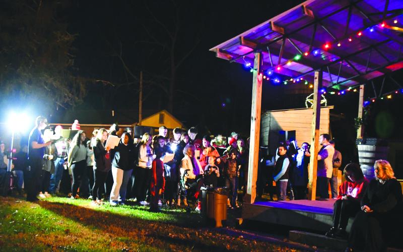 Megan Broome/The Clayton Tribune. Spectators look on as Head of Tennessee Baptist Church Youth Group members sing Christmas Carols to bring cheer to all during the City of Dillard’s Christmas event on Sunday.