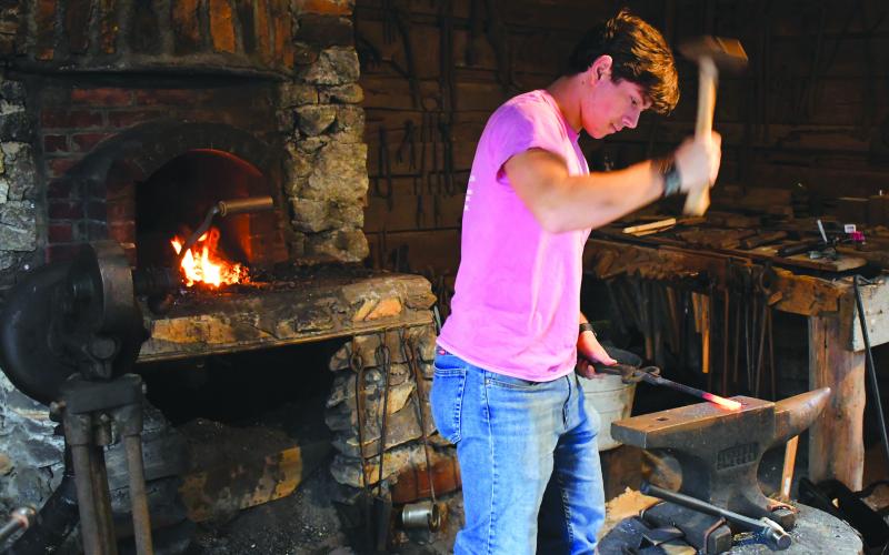 Enoch Autry/The Clayton Tribune. Foxfire Museum volunteer Sam Flaherty works in the Blacksmith Shop on Dec. 10. Visitors came to the shop throughout the day.