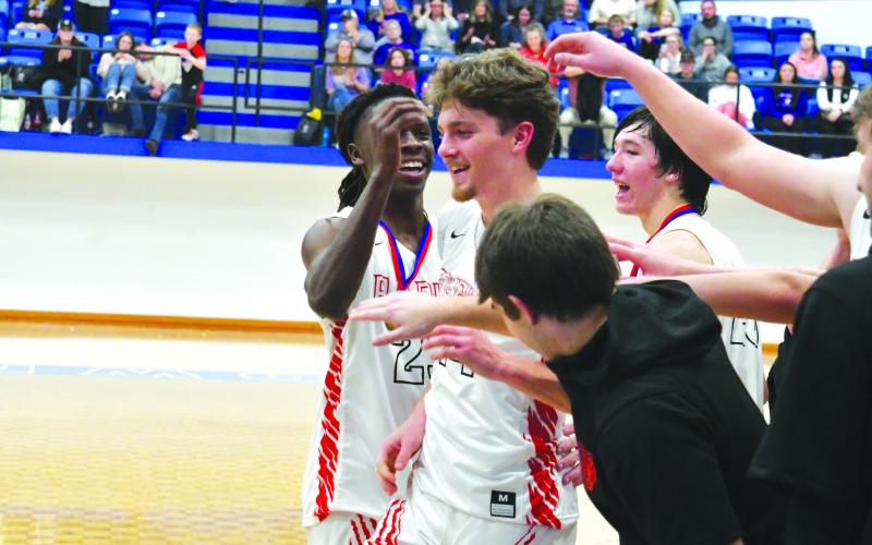 Enoch Autry/The Clayton Tribune.  Teammates Willie Goodwyn and Jayton Henry congratulate Cooper Welch for being named tourney MVP. Goodwyn and Henry also made the all-tournament team. The RCHS boys return to action on the court for home games on Friday and Saturday.