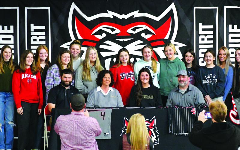 Luke Morey/The Clayton Tribune. Joined by her softball teammates, RCHS senior Mary Lovell signed to play softball at Brenau University on Tuesday, Jan. 31. Seated with Lovell from left to right is softball coach Wes Satterfield and parents Kim and Christian Lovell. 