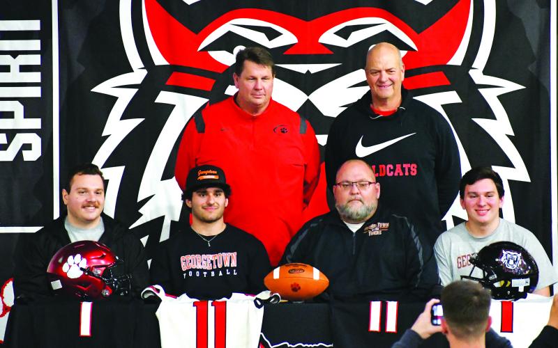 Luke Morey/The Clayton Tribune. Baloga with his family (Zac, father Gregory, and Jacob) with RCHS head coach Michael Davis (standing left) and linebackers coach Jim Pavao. 