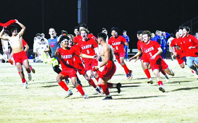 Luke Morey/The Clayton Tribune. With dejected Barrow Arts and Sciences Academy players in the background, the Rabun County Wildcats celebrate a victory in penalties. The game-winning penalty was scored by senior Ezequiel Ramos (pictured center with brother Rodolfo Ramos who is wearing No. 4) on a night where Rabun County honored its seniors. The Lady Cats also picked up a victory over BASA by cruising to a 3-1 win. The Rabun County boys and girls teams only have one more region game until the playoffs begin