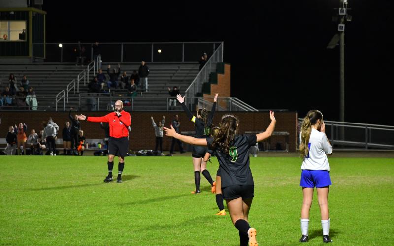 Luke Morey/The Clayton Tribune. With her teammates celebrating in the background, Rabun Gap Lady Eagle Gracie Scott (16) celebrates her goal against Highlands on Wednesday, March 8. Scott, as one of the captains, and the defensive midfielder has helped lead the Lady Eagles to a 6-0-1 start. 