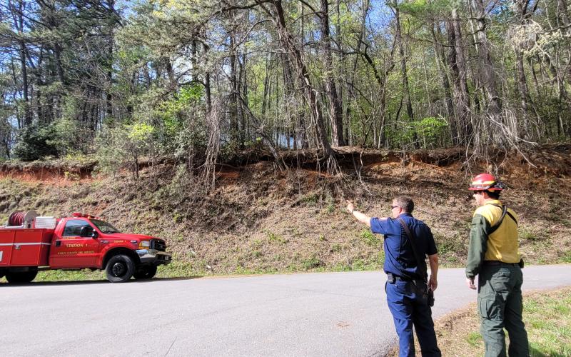 Megan Broome/The Clayton Tribune. Rabun County Fire Services Assistant Chief Justin Upchurch, left, shows a Georgia Forestry Commission worker where the fire on Bettys Creek at Colony Road started. 
