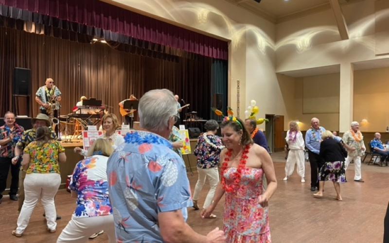 Submitted photo. Matt and Laura Freeman dance to tunes played by Sweet Charity at the April 22 Luau fundraising event held by the Rotary Club of Clayton.