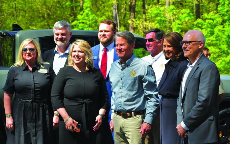 Luke Morey/The Clayton Tribune. At the April 20 ceremony, from left, Public Service Commissioner Tricia Pridemore, Representative Victor Anderson, Senator Bo Hatchett, Kim Anderson, Georgia DNR Commissioner Mark Williams, Gov. Brian Kemp, Georgia State Parks and Historic Sites Director Jeff Cown, Georgia Power CEO Kim Greene and Rivian Chief Legal Officer Michael Callahan pose for a photo during the press conference unveiling three Rivian electric vehicle chargers at Tallulah Gorge State Park. 