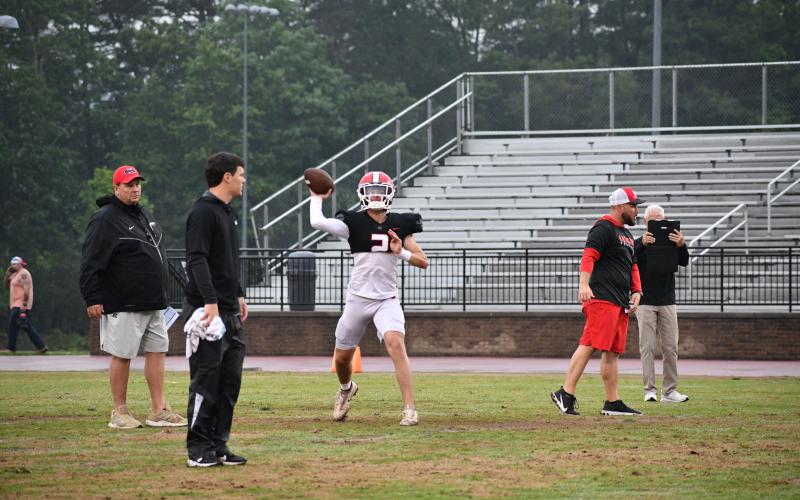 Luke Morey/The Clayton Tribune. Under the watchful eye of RCHS passing game coordinator Wes Holcombe, rising sophomore quarterback Ty Truelove releases a throw during the Spring Game session on May 18. 