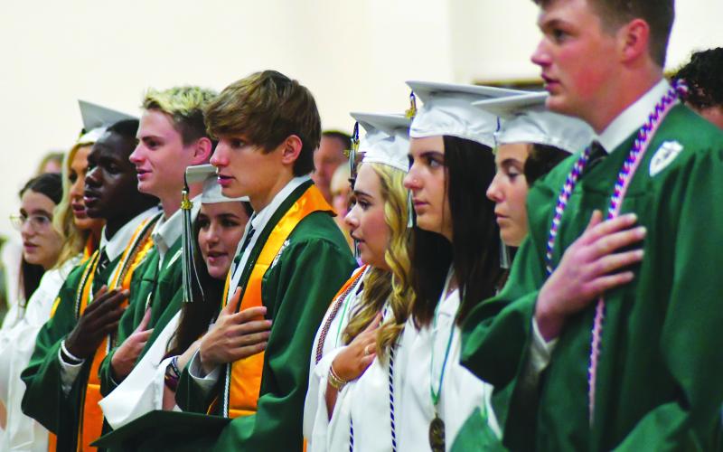 Enoch Autry/The Clayton Tribune. Tallulah Falls Class of 2023 Valedictorian Walker Delaine Bailey (center) and his fellow graduates perform the pledge to U.S. flag at the May 19 ceremony in the school’s Student Activity Center.