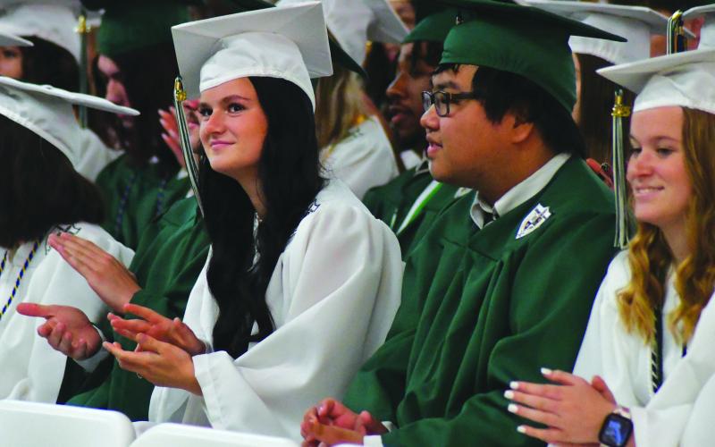 Enoch Autry/The Clayton Tribune. Adeline Higbie, Yuyue “David” Hu and Christy Hulsey cheer on the other graduates from the Tallulah Falls School’s Class of 2023.