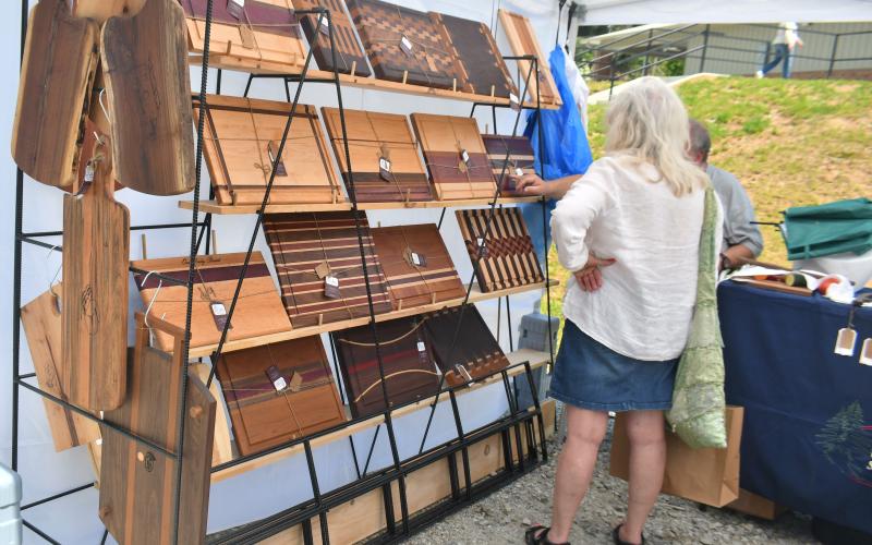 Megan Broome/The Clayton Tribune. Teresa Weiser converses with Hoyt Allison of Allison’s WoodWorks about his beautiful handmade items showcased at the Of These Mountains Spring MarketPlace last weekend. 