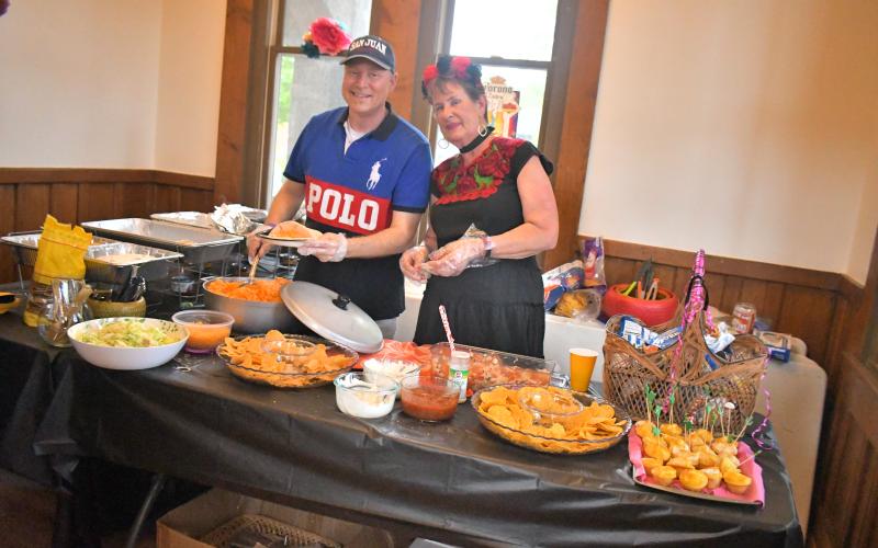 Megan Broome/The Clayton Tribune. Tony Penrose and Patti Estes serve homemade tacos at The Rock House Friday, May 1.