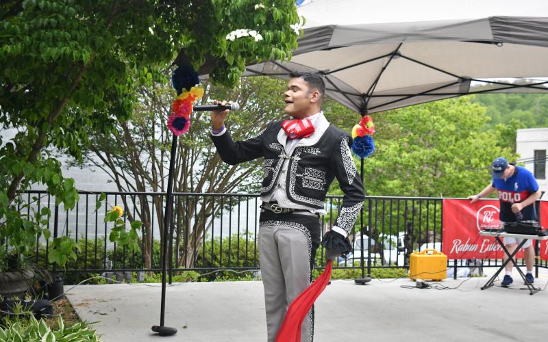 Megan Broome/The Clayton Tribune. Ishmael Santos sings traditional Spanish music while dancing with Rabun Entertainers at a Cinco de Mayo celebration held at The Rock House in Clayton Friday, May 5. Rabun Entertainers performed music in colorful garments.