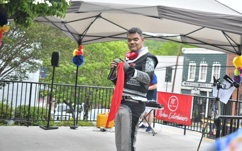 Megan Broome/The Clayton Tribune. Ishmael Santos sings traditional Spanish music while dancing with Rabun Entertainers at a Cinco de Mayo celebration held at The Rock House in Clayton Friday, May 5. Rabun Entertainers performed music in colorful garments. 