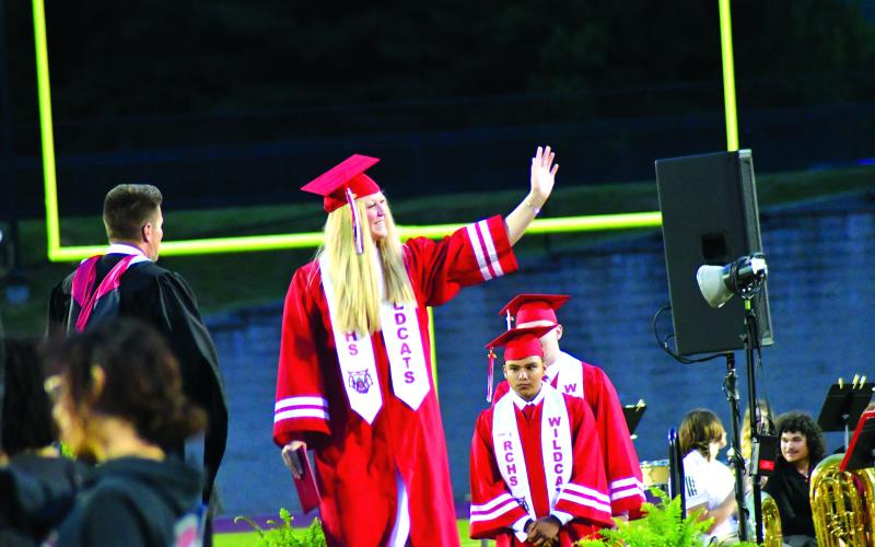 Enoch Autry/The Clayton Tribune. Upon receiving her diploma, graduate Hailey Smith waves to family and friends. 