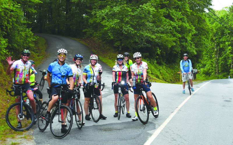 Enoch Autry/The Clayton Tribune. After making it up a steep incline on Bridge Creek Road, bicyclists gather for a respite before heading toward Murray Cove Road.