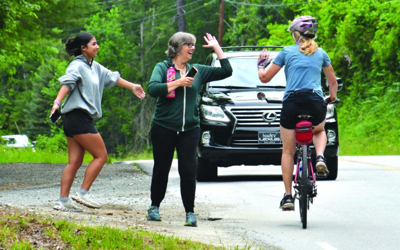 Enoch Autry/The Clayton Tribune. ABOVE:  Bicyclist Stephanie Pohl of Atlanta receives congratulations from happy family members Sara Chauvot and Anna Pohl as the rider pedals near Perrin Cove Road on the Sunday BRAG route.