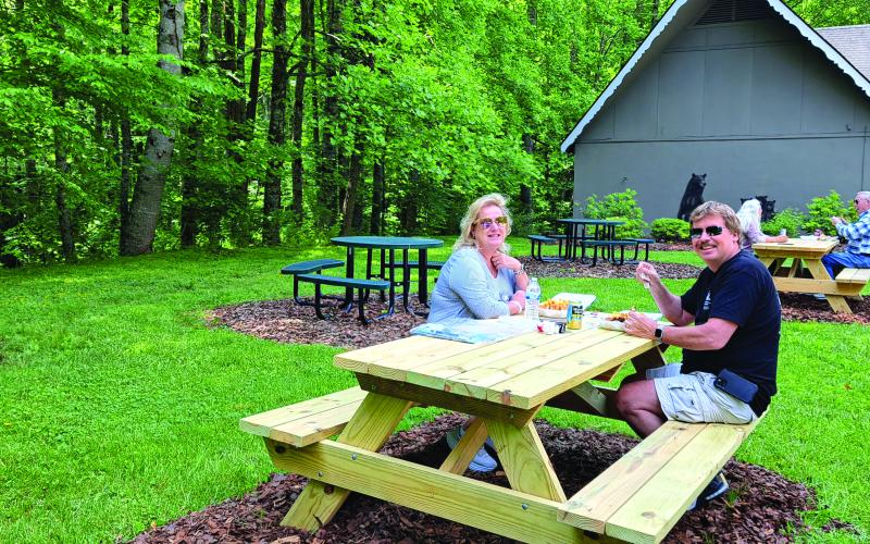 Megan Broome/The Clayton Tribune. Patti and Ryan Simpson enjoy eating lunch from the Park Lounge 10 food truck on the picnic tables outside Sky Valley City Hall for the facility’s grand opening and ribbon-cutting. 