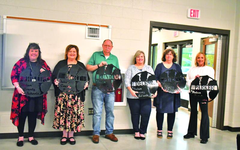 Megan Broome/The Clayton Tribune. Retiring employees at Rabun County Schools were recognized May 18 at the Agri-Science Center and given a gift made by Rabun County students in mechanics class. Pictured are Diane Phillips, RCES teacher (left); Pam Hurt, RCPS music teacher; James Dunham, RCMS custodian; Audrey Decker, RCES nurse; Kelley Curtis, RCES teacher; and Lora Parker, RCES paraprofessional. Not pictured are Memorio Cruz, RCHS custodian; Phil Sidey, RCHS paraprofessional; and Dowana Hopper, bus driver.