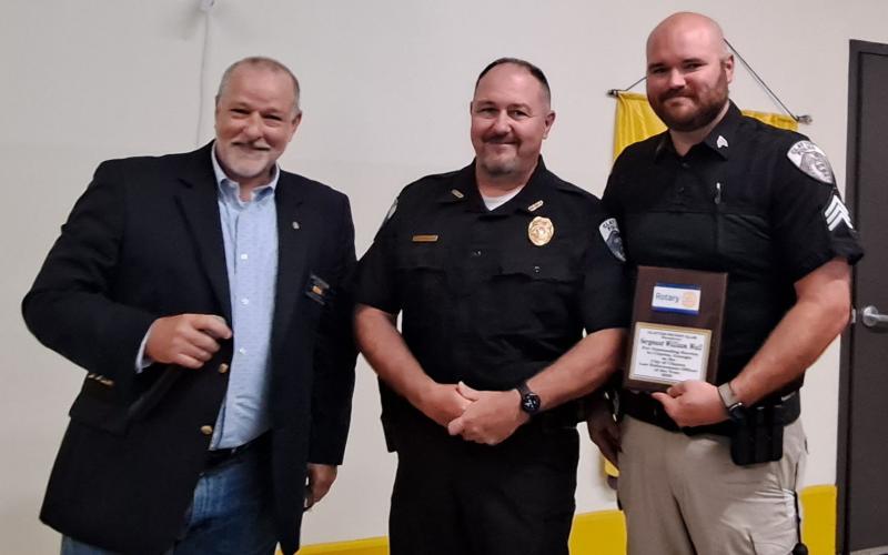 Megan Broome/The Clayton Tribune. Alongside Clayton Police Chief Andy Strait, Clayton Police Department Sgt. William Wall, right, is presented with the Clayton Rotary Club 2023 Law Enforcement Officer of the Year award by Clayton Rotary Club President Leif Ericson at a recent club meeting.