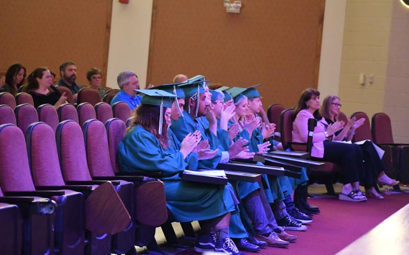 Megan Broome/The Clayton Tribune. MECHS graduates cheer with claps during the graduation ceremony.