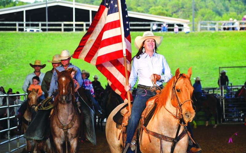Luke Morey/The Clayton Tribune. Bar W Rodeo Company started the night with a procession led by the American Flag. 