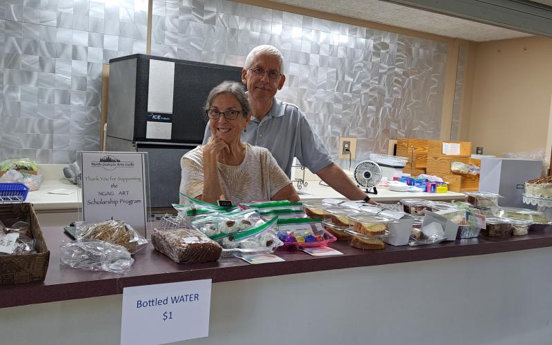 Megan Broome/The Clayton Tribune. Angel and David Dobs volunteer at the bake sale during the Painted Fern Art Festival at the Rabun County Civic Center July 8 and 9. All proceeds for the bake sale benefited the North Georgia Arts Guild Scholarship Program. 