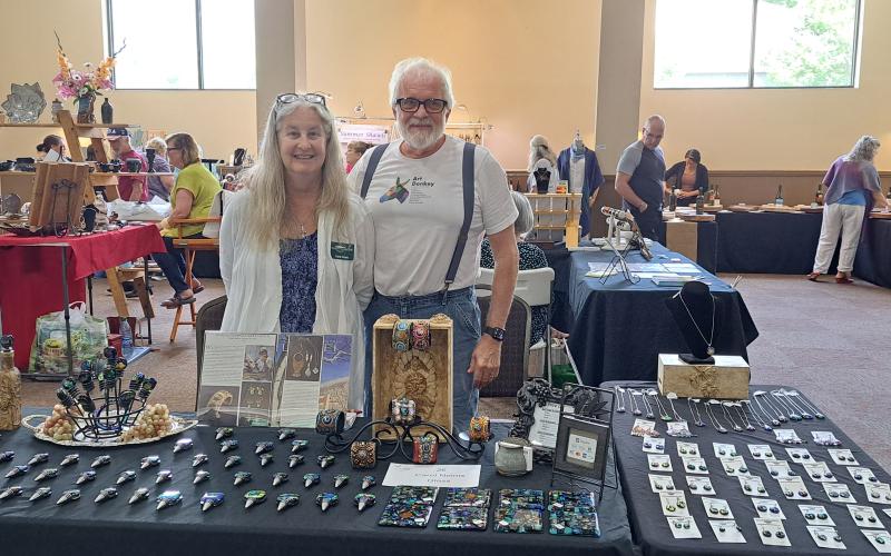Megan Broome/The Clayton Tribune. Tallulah Falls residents Carol and Keith Nelms with Southern Lights Studio showcase unique glass art creations during the Painted Fern Art Festival last weekend. 