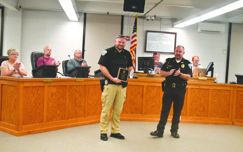 Megan Broome/The Clayton Tribune. Clayton Police Chief Andy Strait presents Sgt. William Wall with a plaque thanking him for his 10 years of service to the community during Tuesday’s Clayton City Council meeting. 