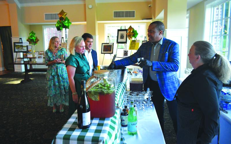 Enoch Autry/The Clayton Tribune. Carlton Chamblin of Farm2Cocktail prepares to serve Sarah and Jonathon Barge and Bethany Weisser at the Aug. 4 Green & Gold Gala.