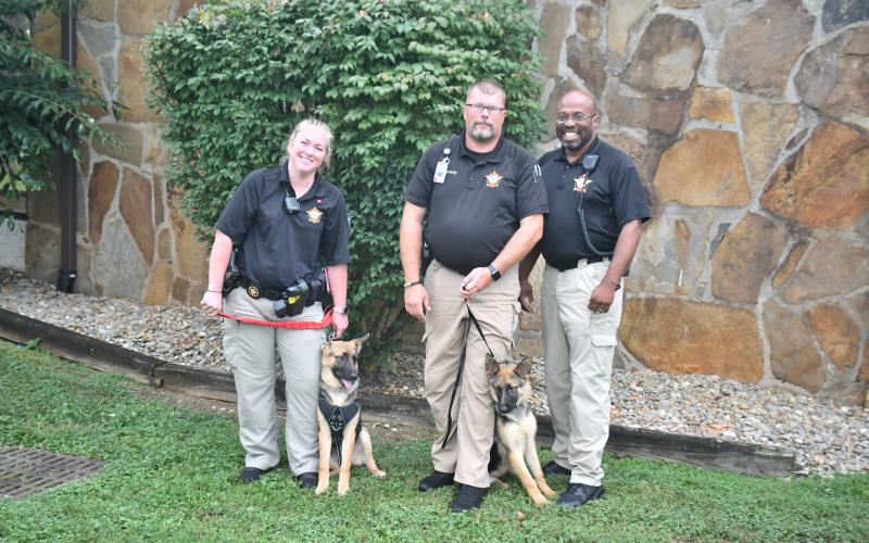 Megan Broome/The Clayton Tribune.  German Shepherd K9s “Honor” and “Nova” are new additions to Rabun County Schools for the upcoming years. School Resource Deputies Lindsey Owens, Eric McKinney and Lisa Thompson introduced the K9s during the Board of Education meeting August 3. Below:Enoch Autry/The Clayton Tribune. RCES student Reese Dean selects the book “Ranger In Time” from the school library. 