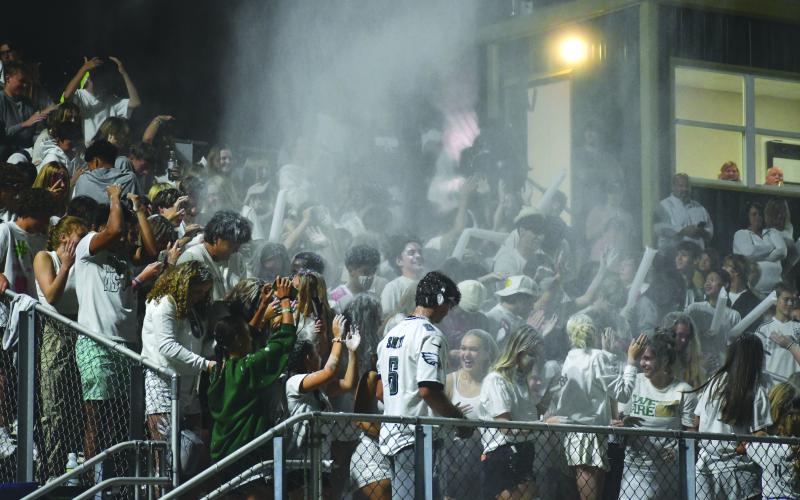 Wade Cheek/The Clayton Tribune. RGNS students toss white powder up into the stands in celebration of the Eagles victory.