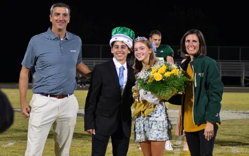 Enoch Autry/The Clayton Tribune.  Head of School Jeff Miles and his wife Kiana stand with King Marcelo Gonzalez and Haven Bejnerowicz.