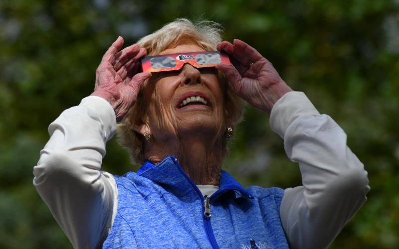 Enoch Autry/The Clayton Tribune. Dottie Haney of Sky Valley uses her solar viewing glasses to look at the solar eclipse while at Black Rock Mountain State Park on Oct. 11.