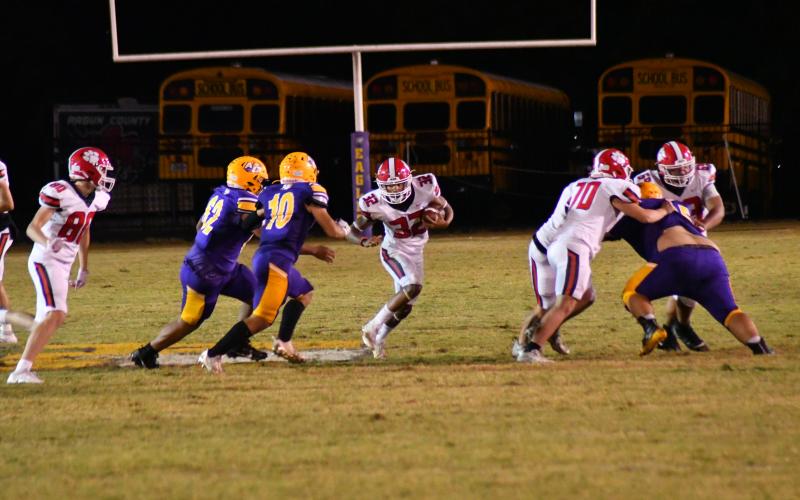 Wade Cheek/The Clayton Tribune. RCHS running back Kane Justice evades Athens Christian defenders on Oct. 20 as the freshman piled up 132 yards rushing and notched his first career touchdown. 