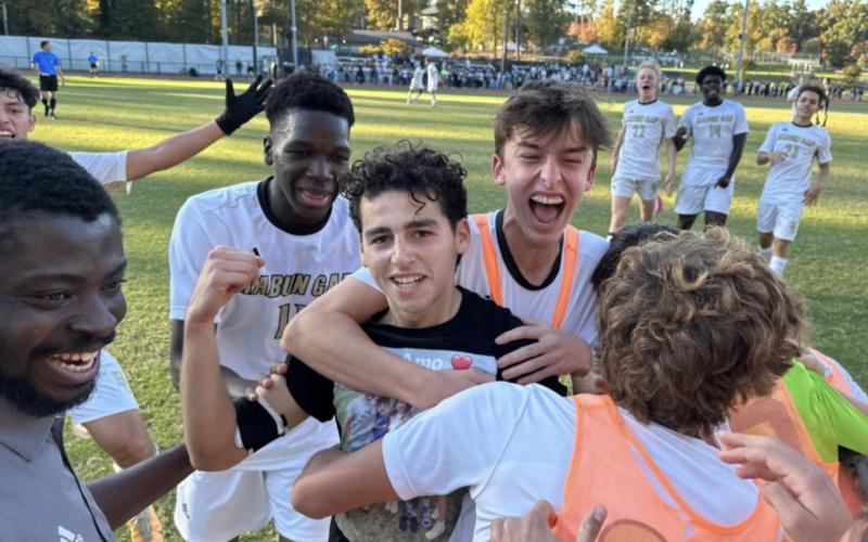 Wade Cheek/The Clayton Tribune. RGNS senior Marcelo Gonzalez (center) celebrates after icing the Durham Academy in the final minutes of Tuesday’s semifinal game versus the Cavaliers. The Eagles won 3-1 on the road and are now set to defend their state title.