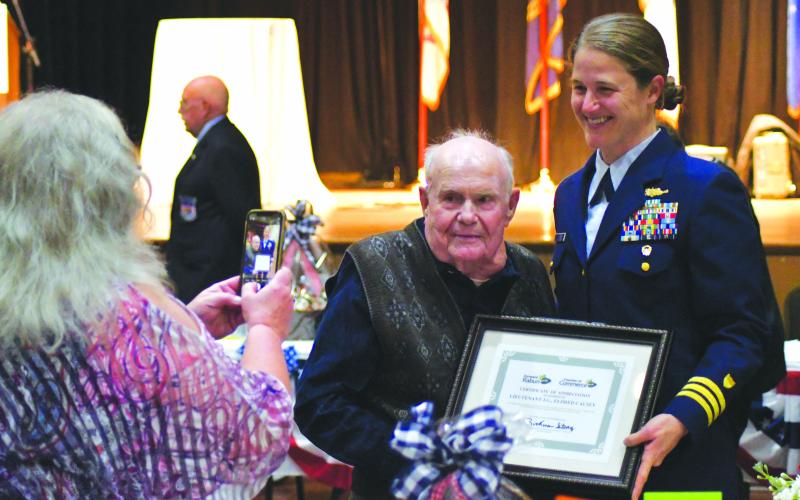 Enoch Autry/The Clayton Tribune. Kathy Causey takes a photograph of her father Eldrid Causey with Commander Sarah Ernst at the conclusion of the 24th Annual Veterans Appreciation Dinner on Nov. 9 at the Rabun County Civic Center. Ernst told the audience about 99-year-old Causey who served in WWII and was the oldest veteran at the event.