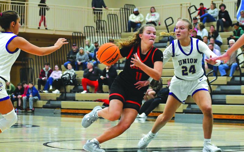 Wade Cheek/The Clayton Tribune. Rabun County senior Lady Cat Lucy Hood drives past Union County’s Paula Robertson in the Piedmont University Hardwood Classic on Nov. 21. Hood’s 41 points in the game helped RCHS come back from a 19-point deficit to win the title 82-80.