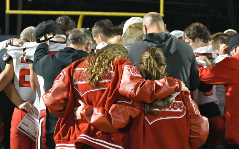 Wade Cheek/The Clayton Tribune. Players, coaches and managers bow their heads in prayer as a team after Rabun County loses in the Class A Division I state quarterfinals to host Brooks County, 39-13 on Nov. 24. This would be the Wildcats’ ninth consecutive trip to the Elite Eight as hundreds of RCHS fans made the five-hour, 317-mile drive to Quitman. Brooks County and Swainsboro meet Friday for a spot in the state title game.
