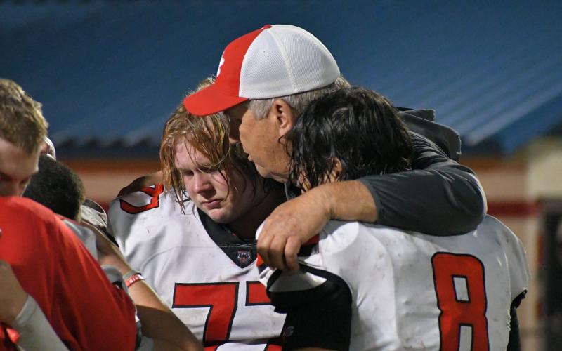 Wade Cheek/The Clayton Tribune. Rabun County defensive line coach Eric Richeson consoles his linemen after the Wildcats lose to the Brooks County 39-13 in the Elite Eight of the state playoffs.
