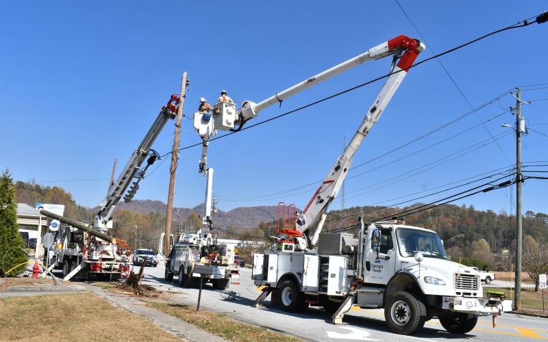 Megan Horn/The Clayton Tribune. Georgia Power crews work in bucket trucks to replace a power pole Tuesday that was completely knocked down due to a one-vehicle crash on North Main Street at Paris Street. 