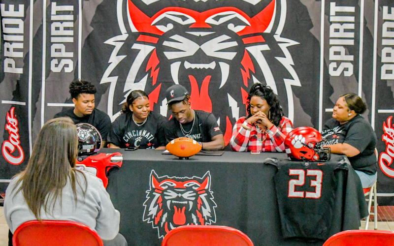 Wade Cheek/The Clayton Tribune. Rabun County Wildcat standout Willie Goodwyn signs his letter of intent to play football for the University of Cincinnati Bearcats Monday.