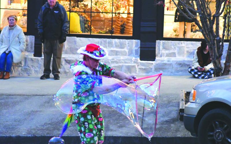 Enoch Autry/The Clayton Tribune. Prior to the start of the Dec. 8 Clayton Christmas Parade, Tyler Ratcliffe, AKA “Bubble Man,” showed off his propensity to create some really big bubbles that would stretch several feet before popping.