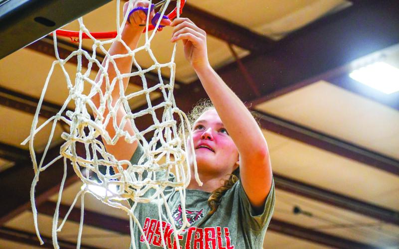 Wade Cheek/The Clayton Tribune. Lady Cat standout and Region 8 Player of the Year, Lucy Hood helps cut down the net at Athens Christian Academy after RCHS defeated the Lady Eagles in this year’s region title game on Friday, Feb. 16. 