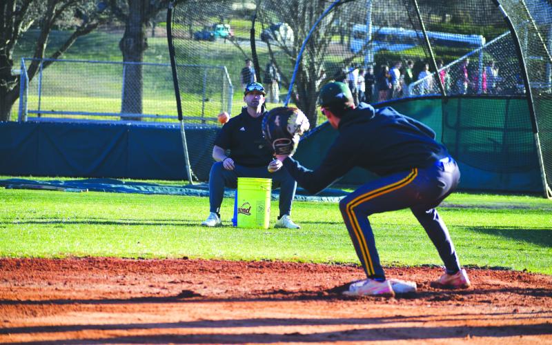 Wade Cheek/The Clayton Tribune. RGNS head baseball coach Clark Wright does infield work with Eagle senior Argenis Lopez at third base during a Feb. 13 practice. The Eagles will kick off their season Friday, Feb. 16 against North Atlanta at Pickens County High School. 
