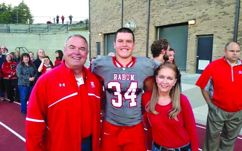 Photo courtesy of Woerner family. Charlie Woerner (center) stands with his mother Kathie Woerner and his father Kent Woerner during a Rabun County football game. 